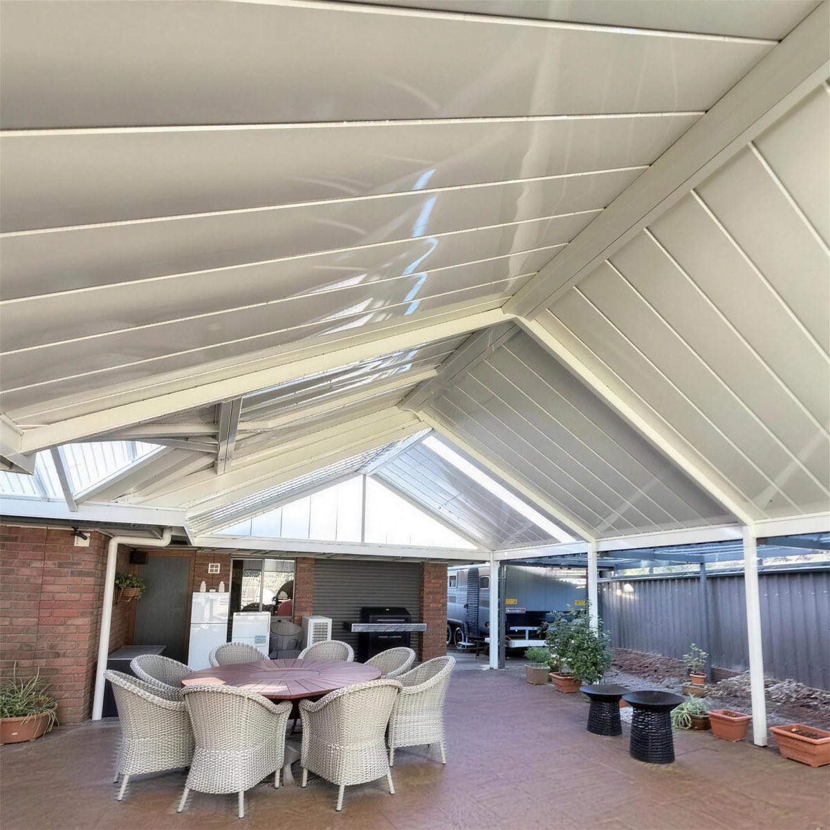 Alfresco outdoor kitchen and dining area with ceiling fan
